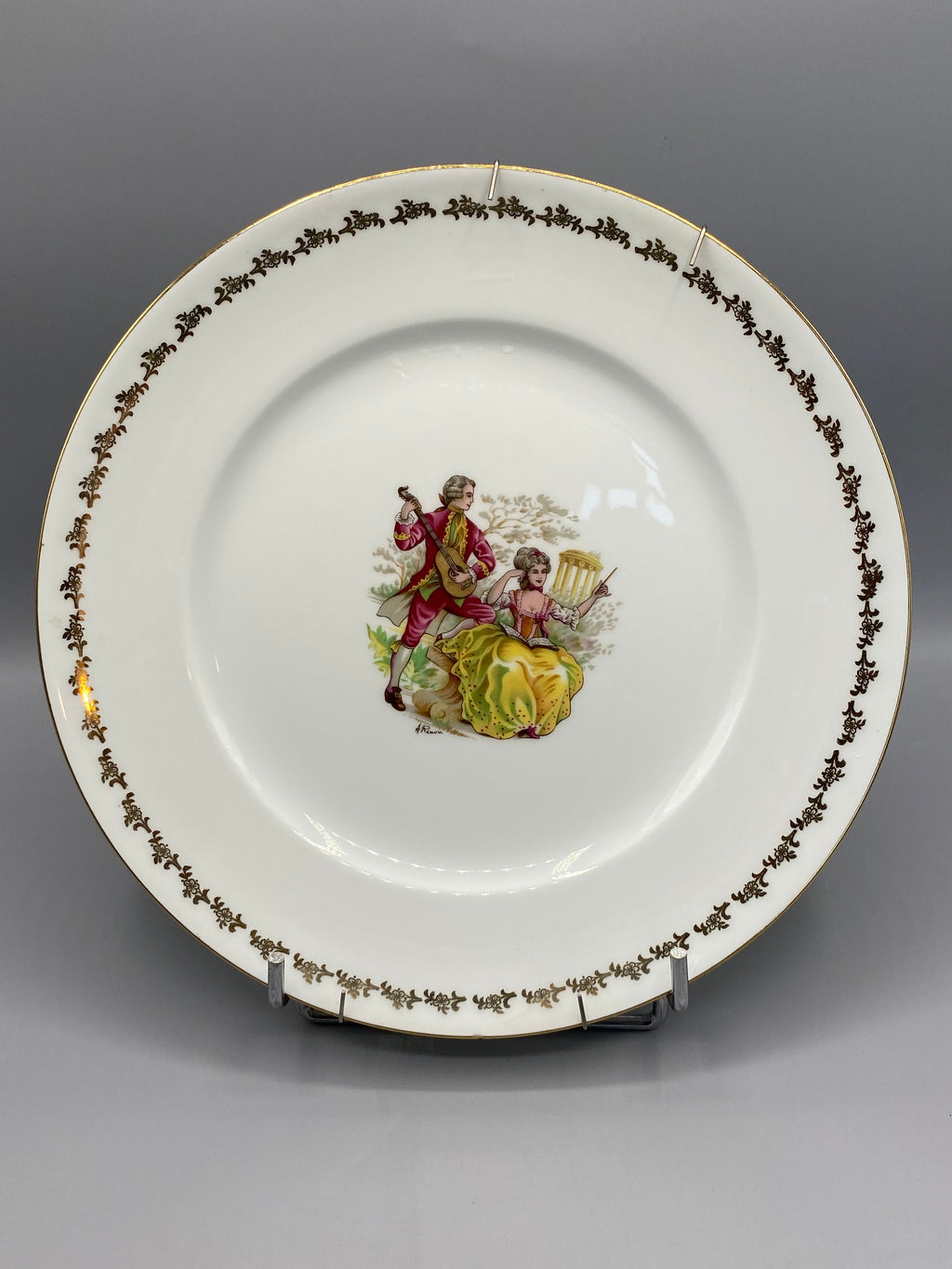 Assiette décorative porcelaine Limoges Pégut, scène galante cavalier et dame, frise dorée, vue de face