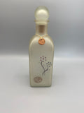 Flacon carafe verre dépoli satiné ivoire nacré, motifs floraux graphiques, médaille cuivrée au col, vue de face