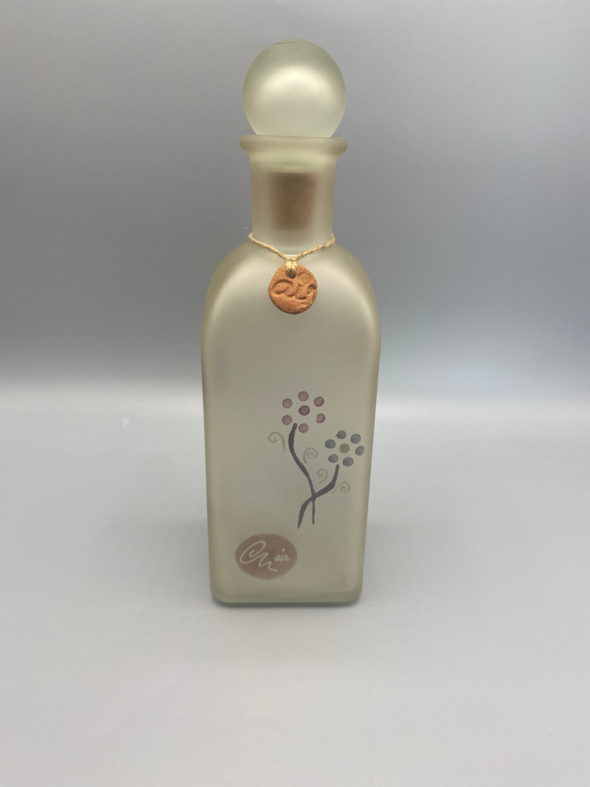 Flacon carafe verre dépoli satiné ivoire nacré, motifs floraux graphiques, médaille cuivrée au col, vue de face