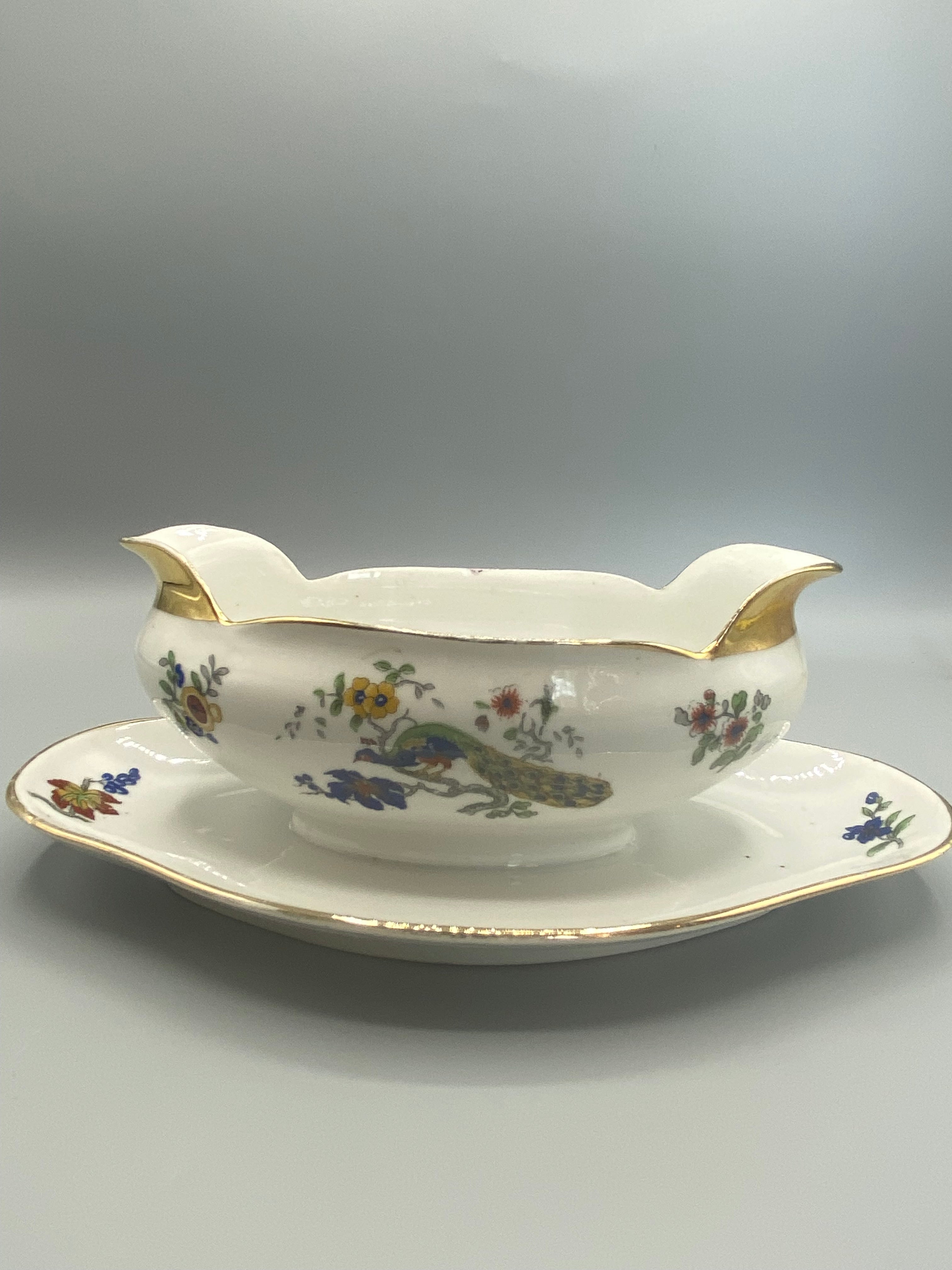Saucière porcelaine Limoges Charles Field Haviland GDA, décor paon et fleurs polychromes, vue de face avec présentoir