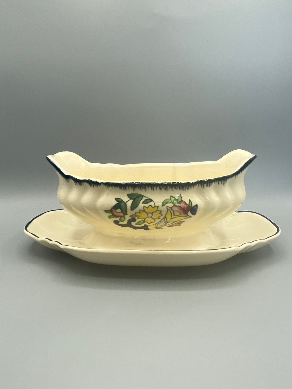 Saucière faïence Longwy, décor floral peint main, panse côtelée, vue de face avec présentoir