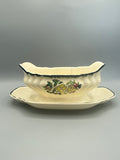 Saucière faïence Longwy, décor floral peint main, panse côtelée, vue de face avec présentoir