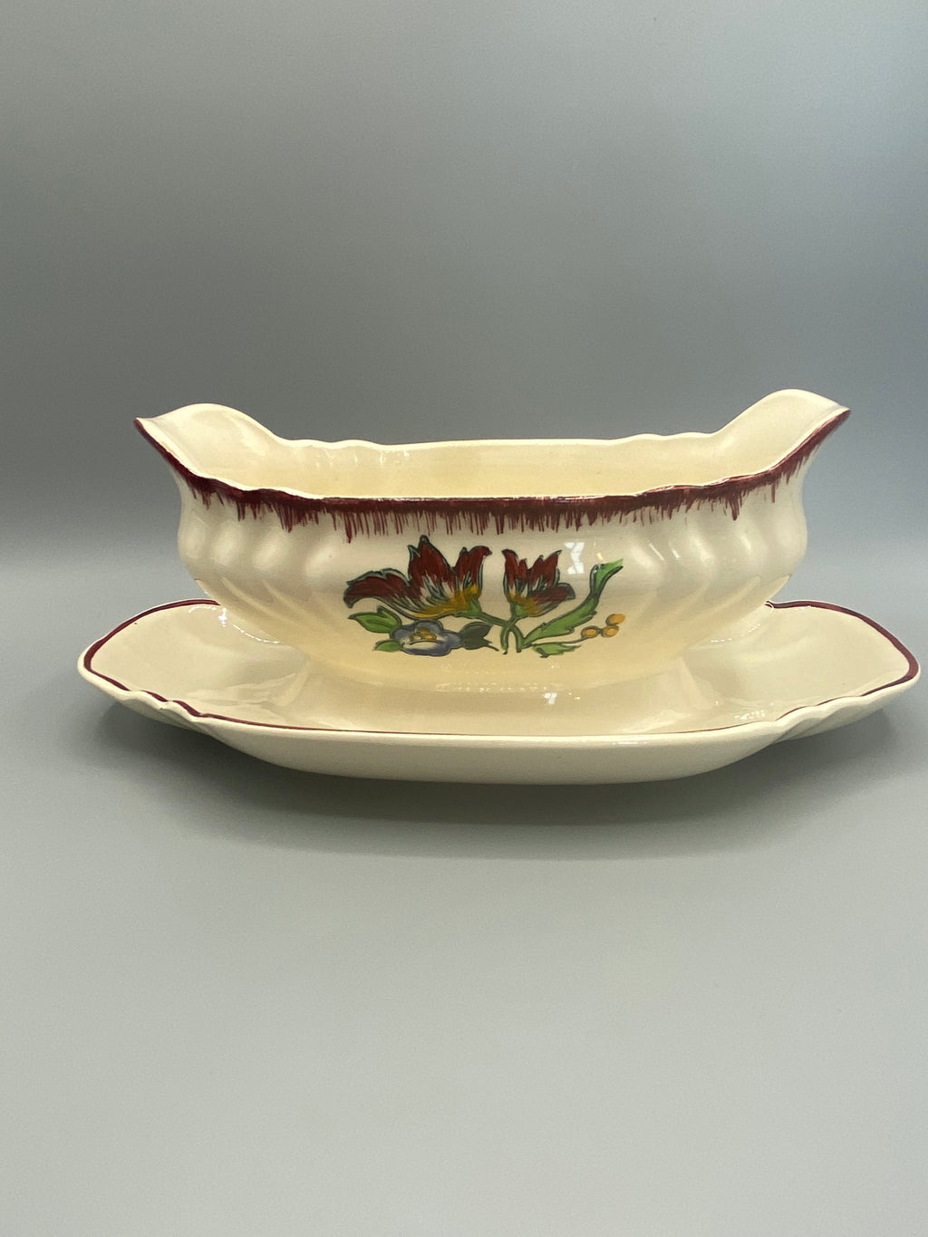 Saucière faïence Longwy décor Marseille, tulipes brun et vert, vue de face avec présentoir