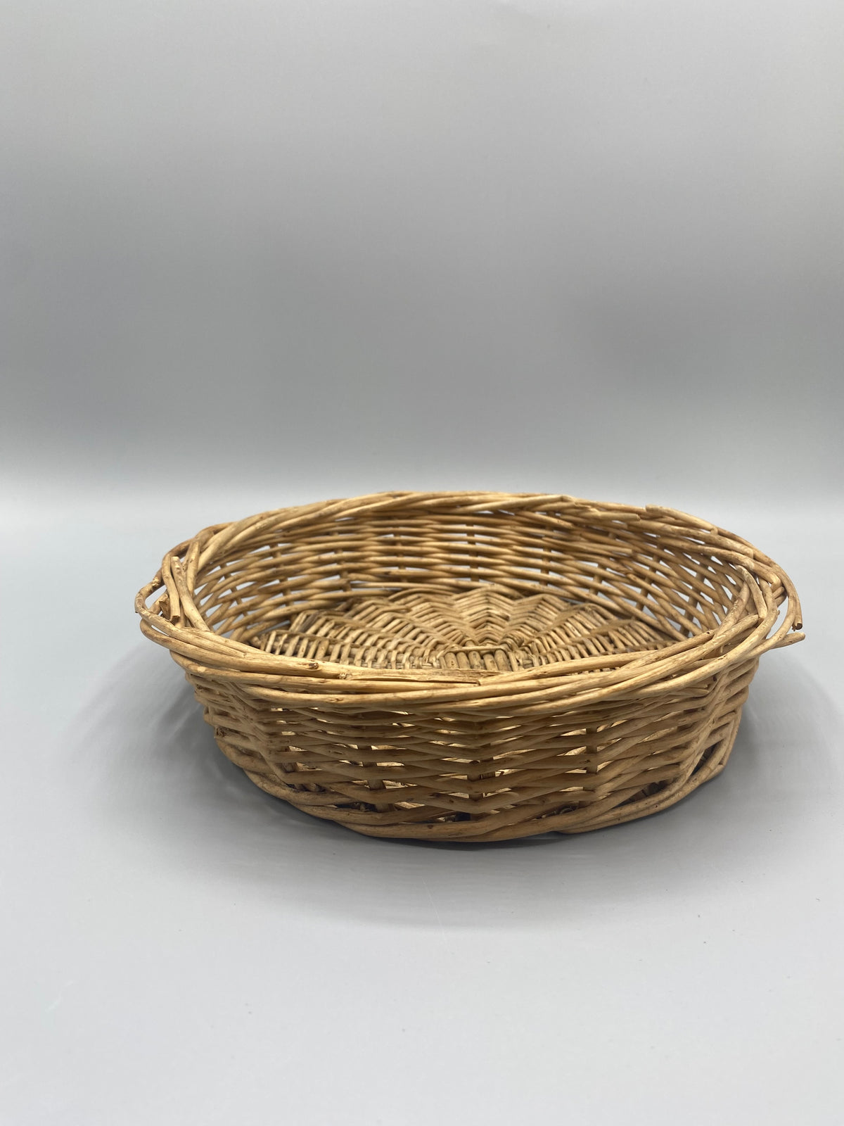Corbeille ronde en osier tressé vintage, vue de trois quarts