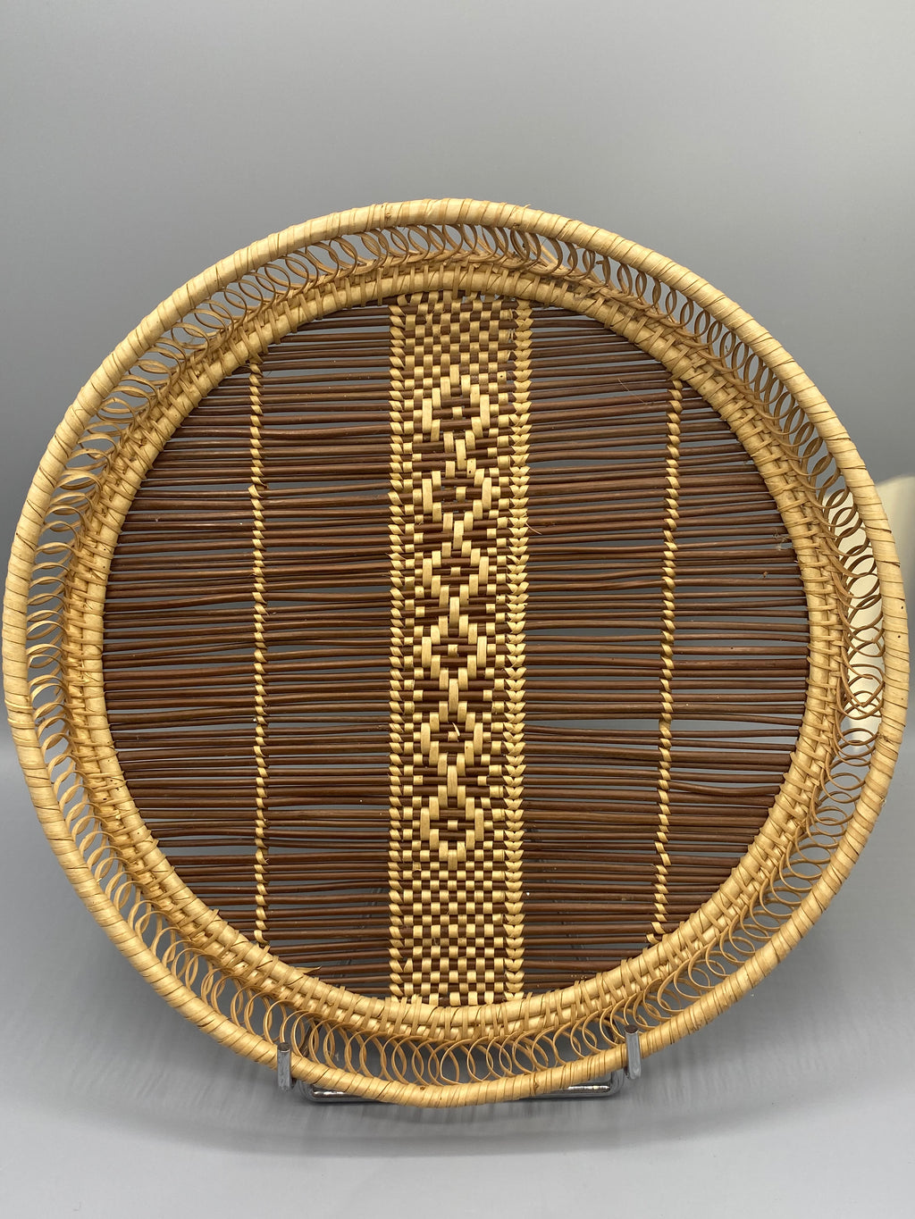 Plateau rond en rotin tressé, vue de face, motif losanges et bordure spirale