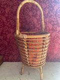 Grande travailleuse de couture en rotin, vue de face, garniture fleurie rouge-orangé