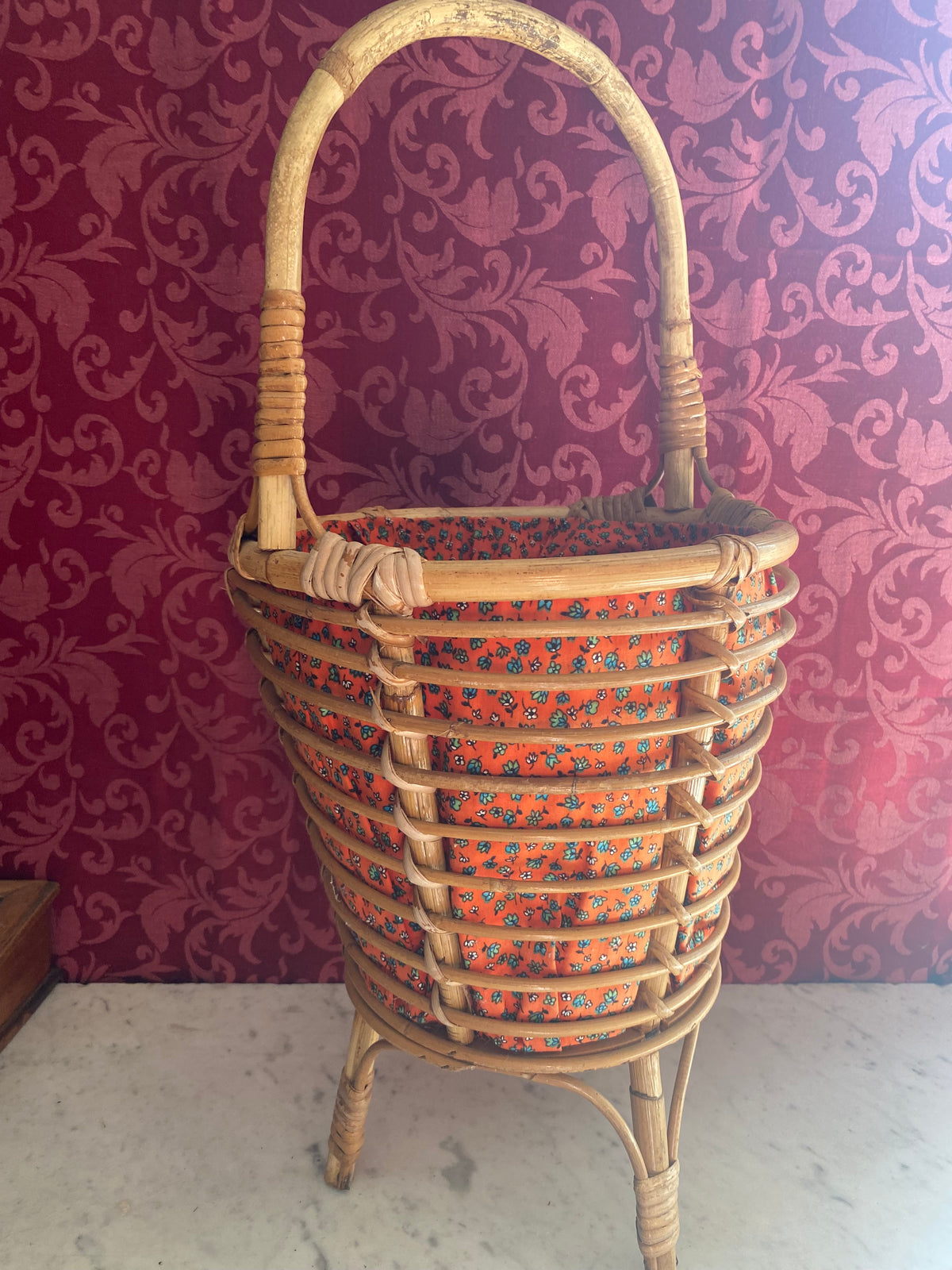 Grande travailleuse de couture en rotin, vue de face, garniture fleurie rouge-orangé