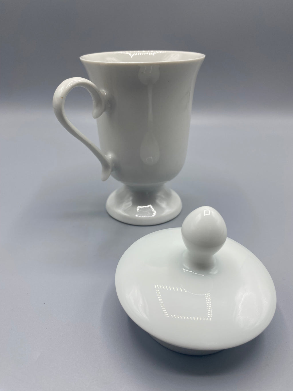Tasse à thé porcelaine blanche sur pied, couvercle ouvert, vue de dos