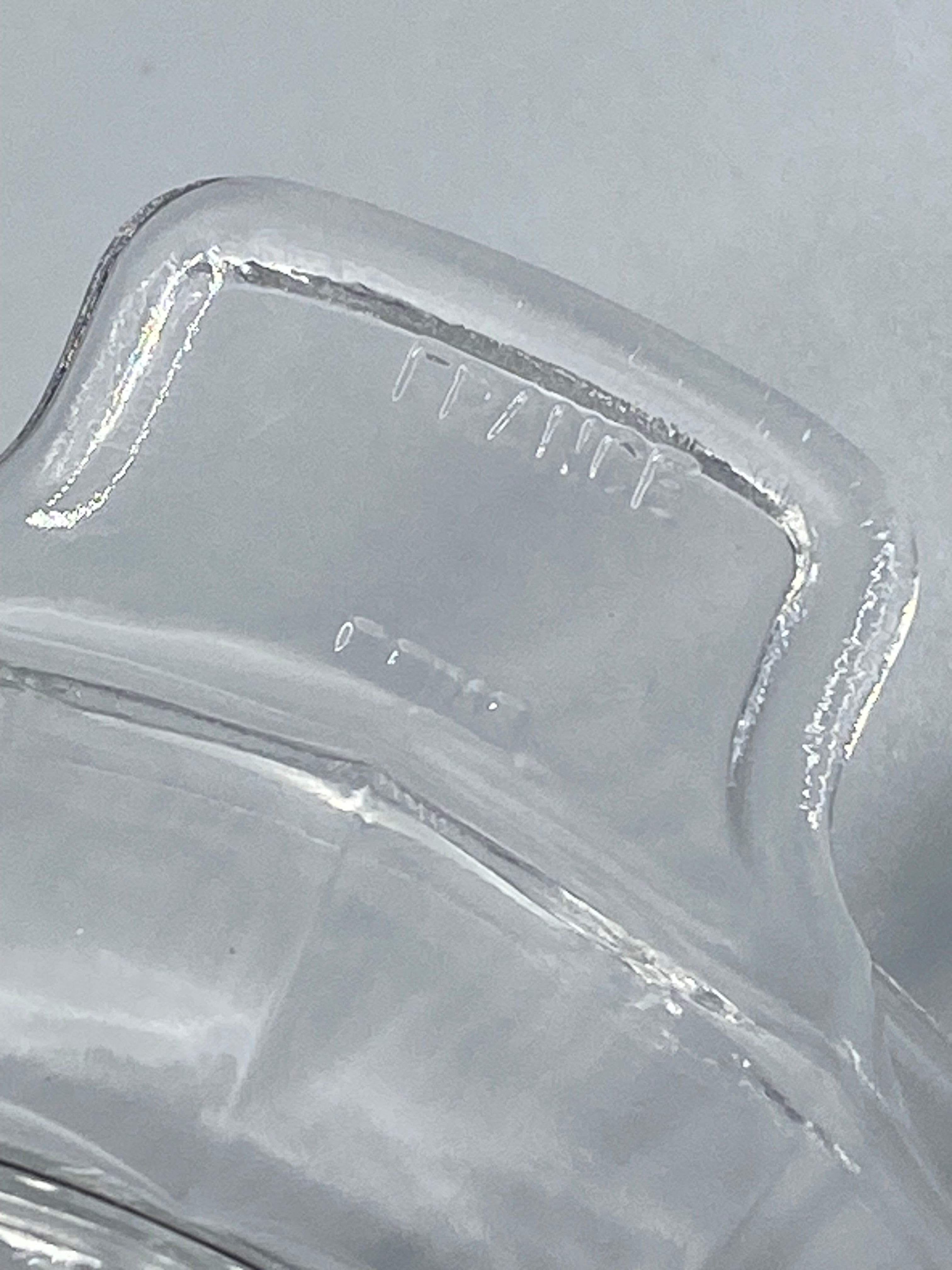Détail du bec verseur et des anses latérales du presse-agrumes en verre pressé