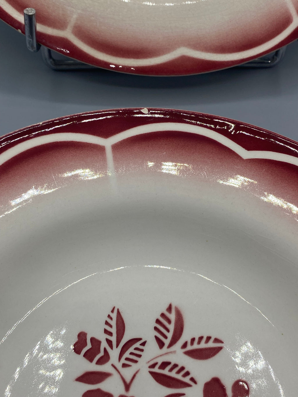 Détail bord assiette avec petit éclat ponctuel visible, festons géométriques