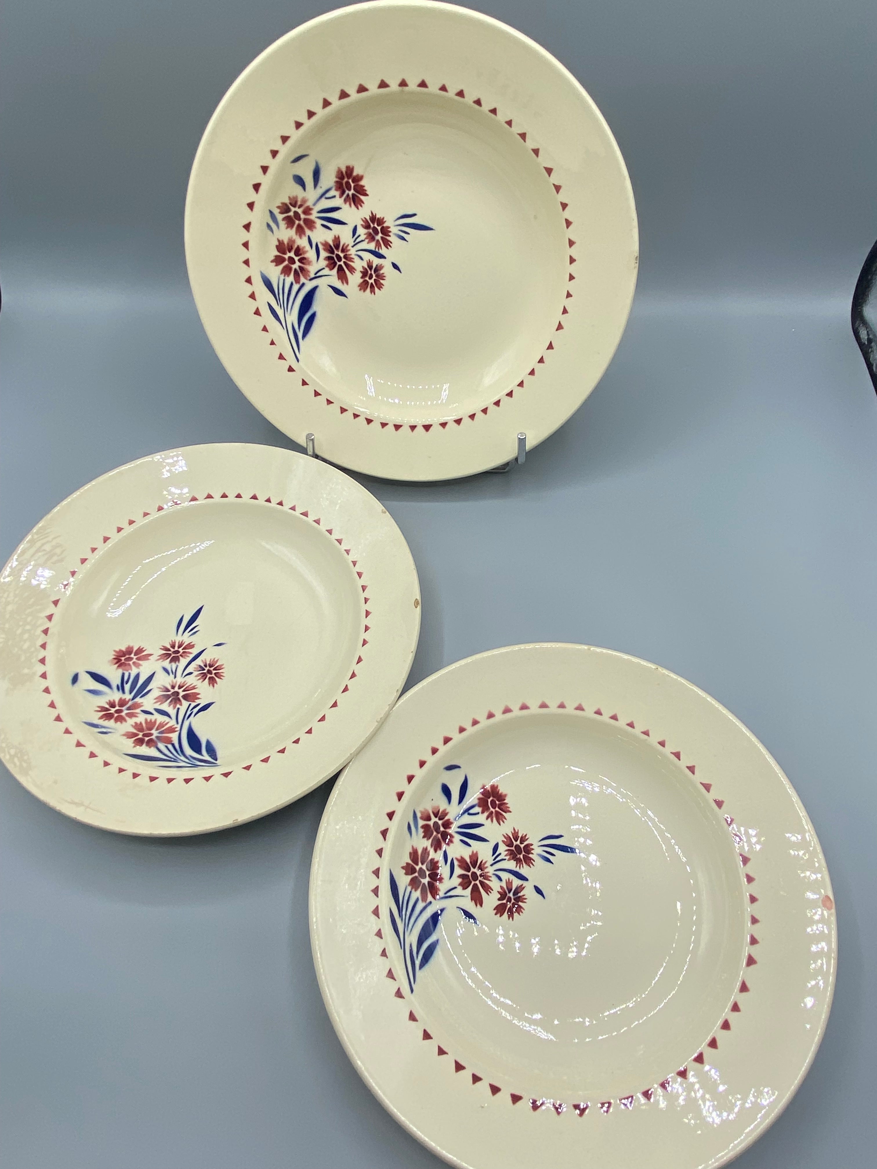 3 assiettes creuses faïence Lunéville, vue d'ensemble, décor floral rouge et bleu sur fond ivoire