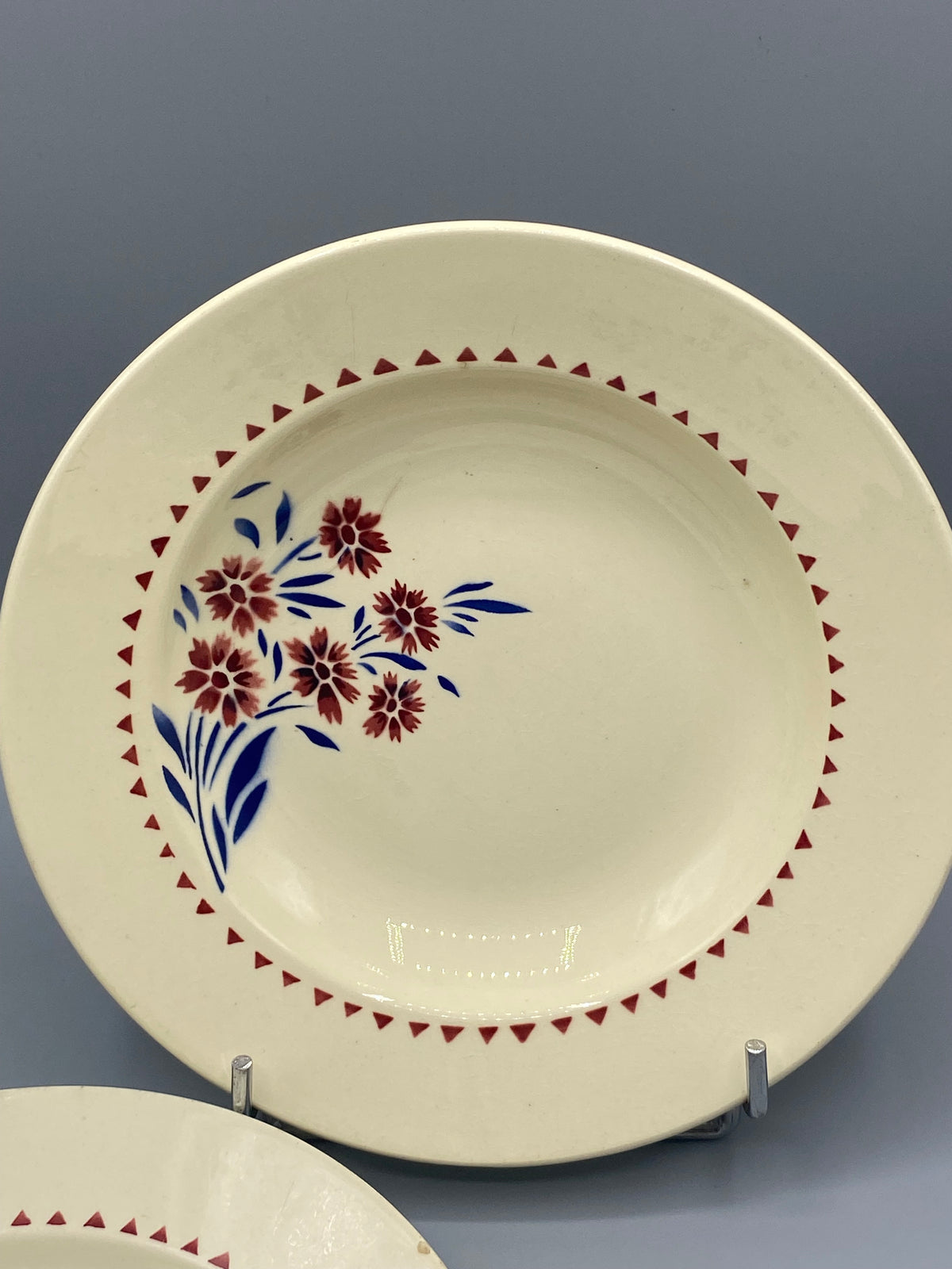 Assiette creuse Lunéville, vue de face, bouquet fleurs rouge lie-de-vin et feuillages bleus