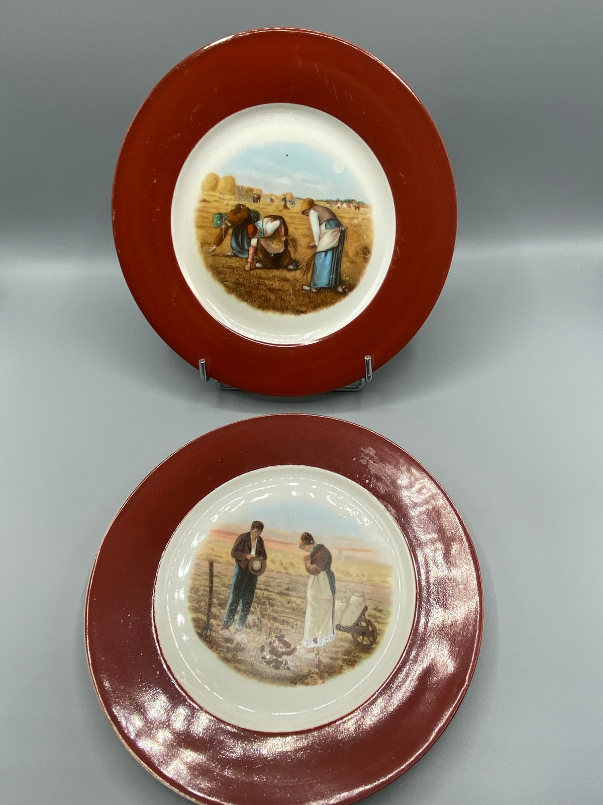 Vue d'ensemble des 2 assiettes Millet, marli bordeaux brillant, scènes paysannes chromolithographie