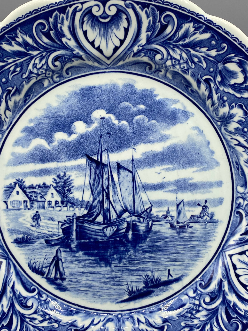 Détail centre assiette Delfts, voiliers traditionnels hollandais sur l'eau, moulin à vent et maisons en arrière-plan