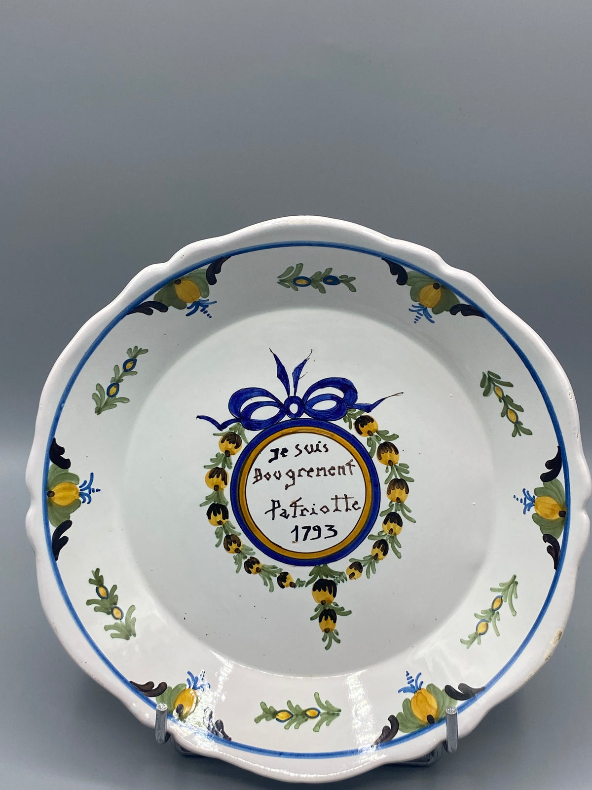 Assiette parlante faïence de Nevers, Je suis Bougrement Patriotte 1793, vue de face, médaillon bleu et or, nœud de ruban bleu