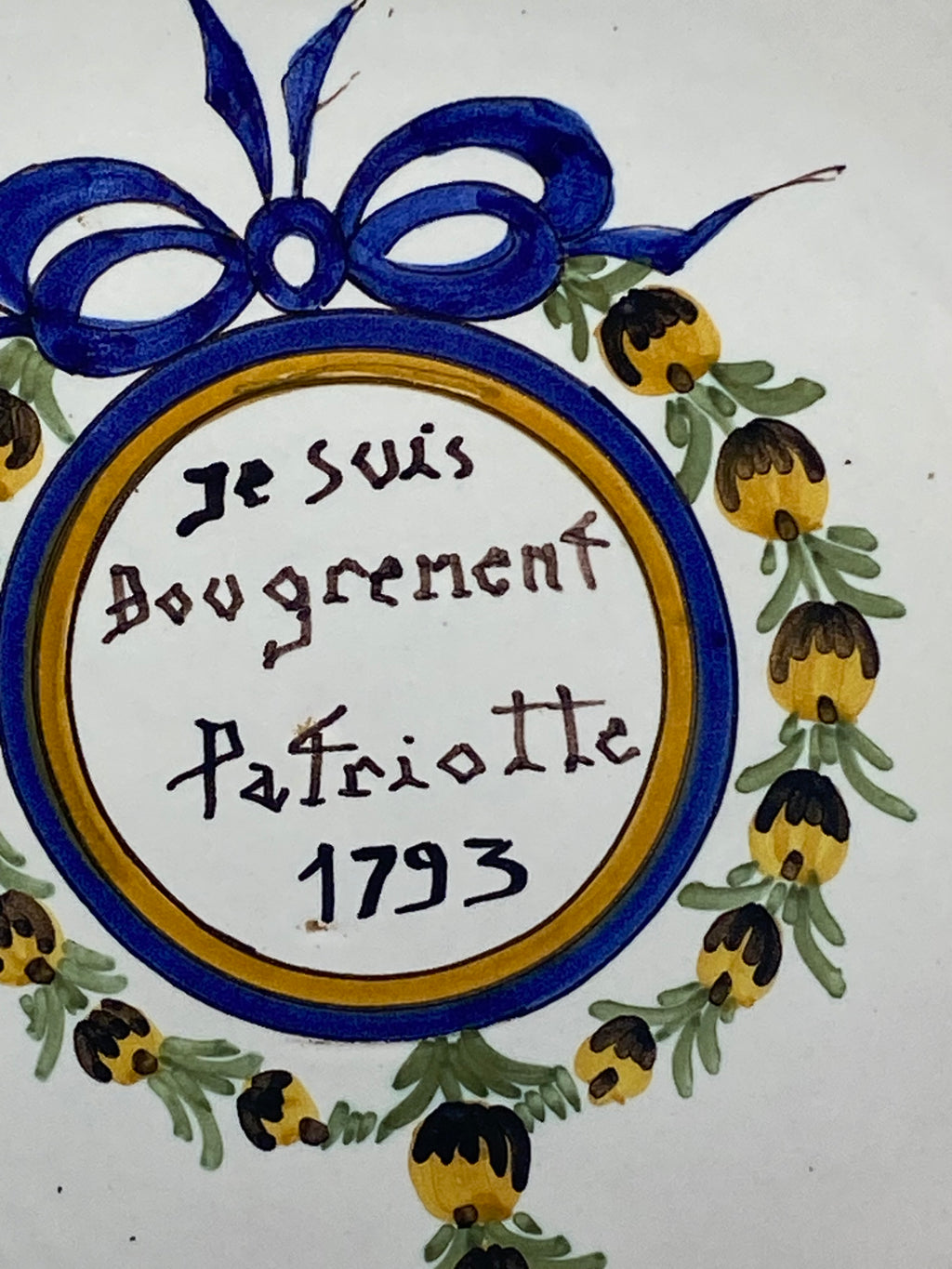 Détail inscription Je suis Bougrement Patriotte 1793, calligraphie manuscrite dans médaillon cerclé de bleu et d'or