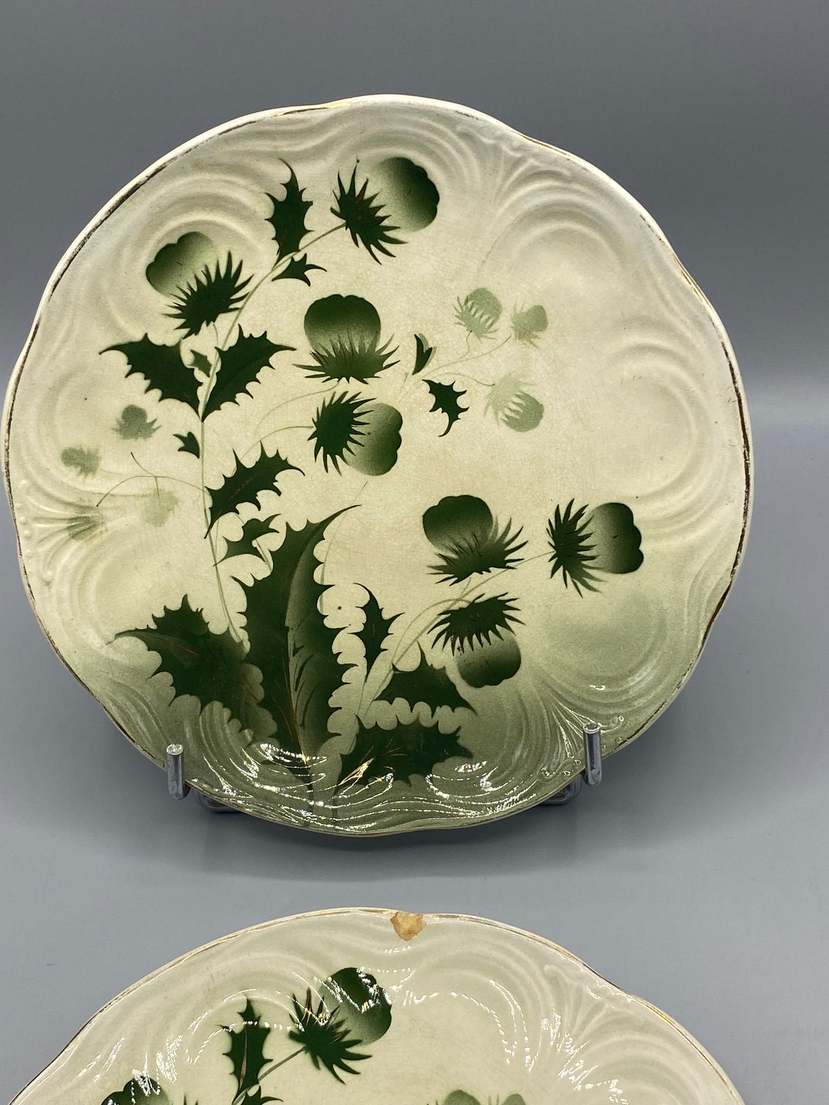 Vue de face assiette à dessert Badonviller, chardons asymétriques Art nouveau, filet doré patiné