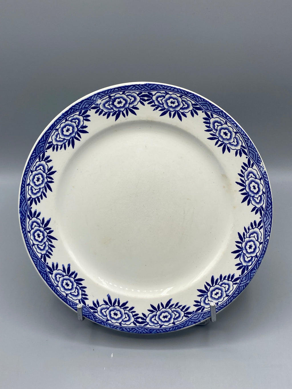 Assiette plate Digoin Sarreguemines modèle Capri, couronne de fleurs stylisées bleu cobalt sur fond blanc, frise losanges