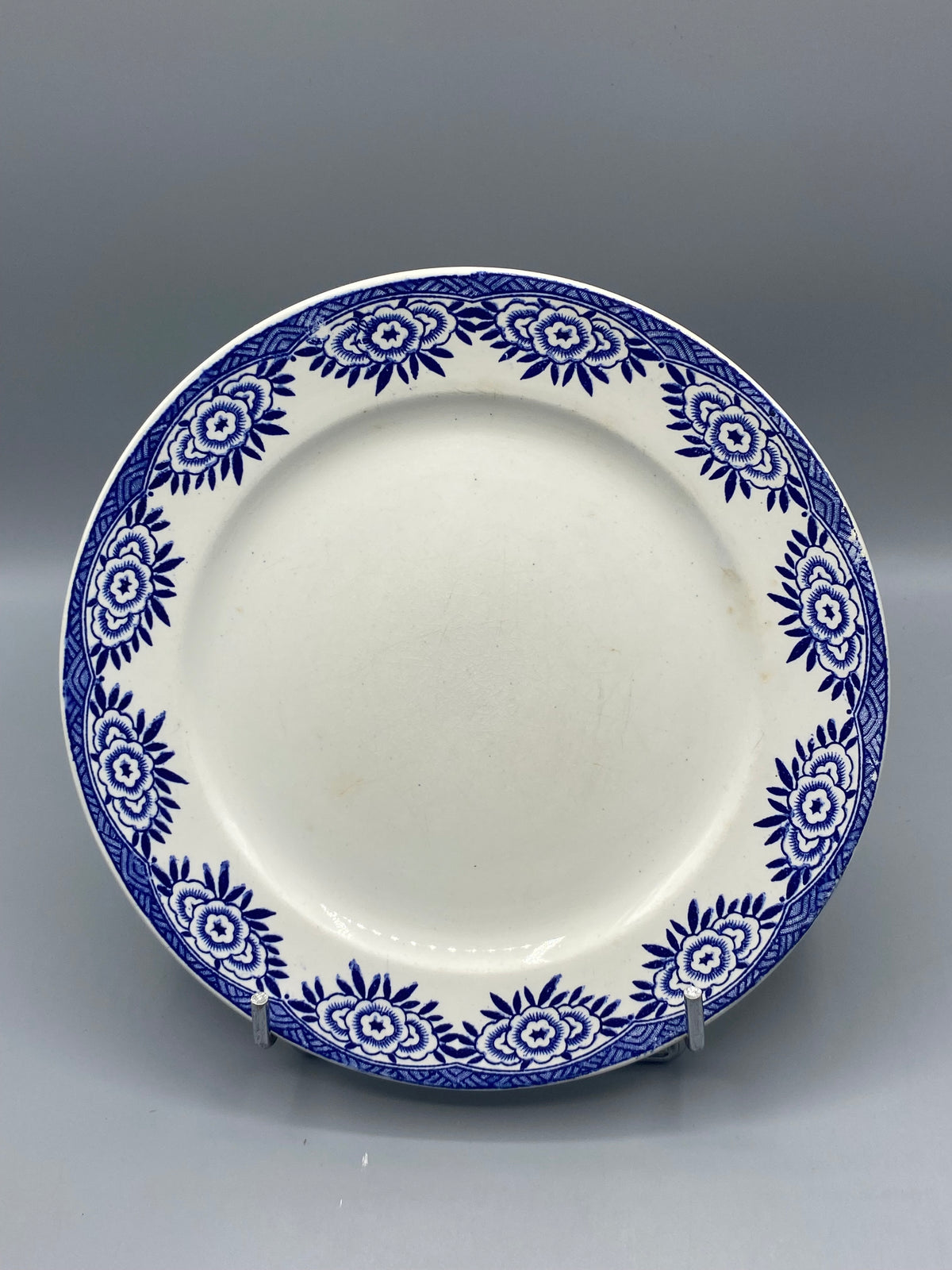 Assiette plate Digoin Sarreguemines modèle Capri, couronne de fleurs stylisées bleu cobalt sur fond blanc, frise losanges