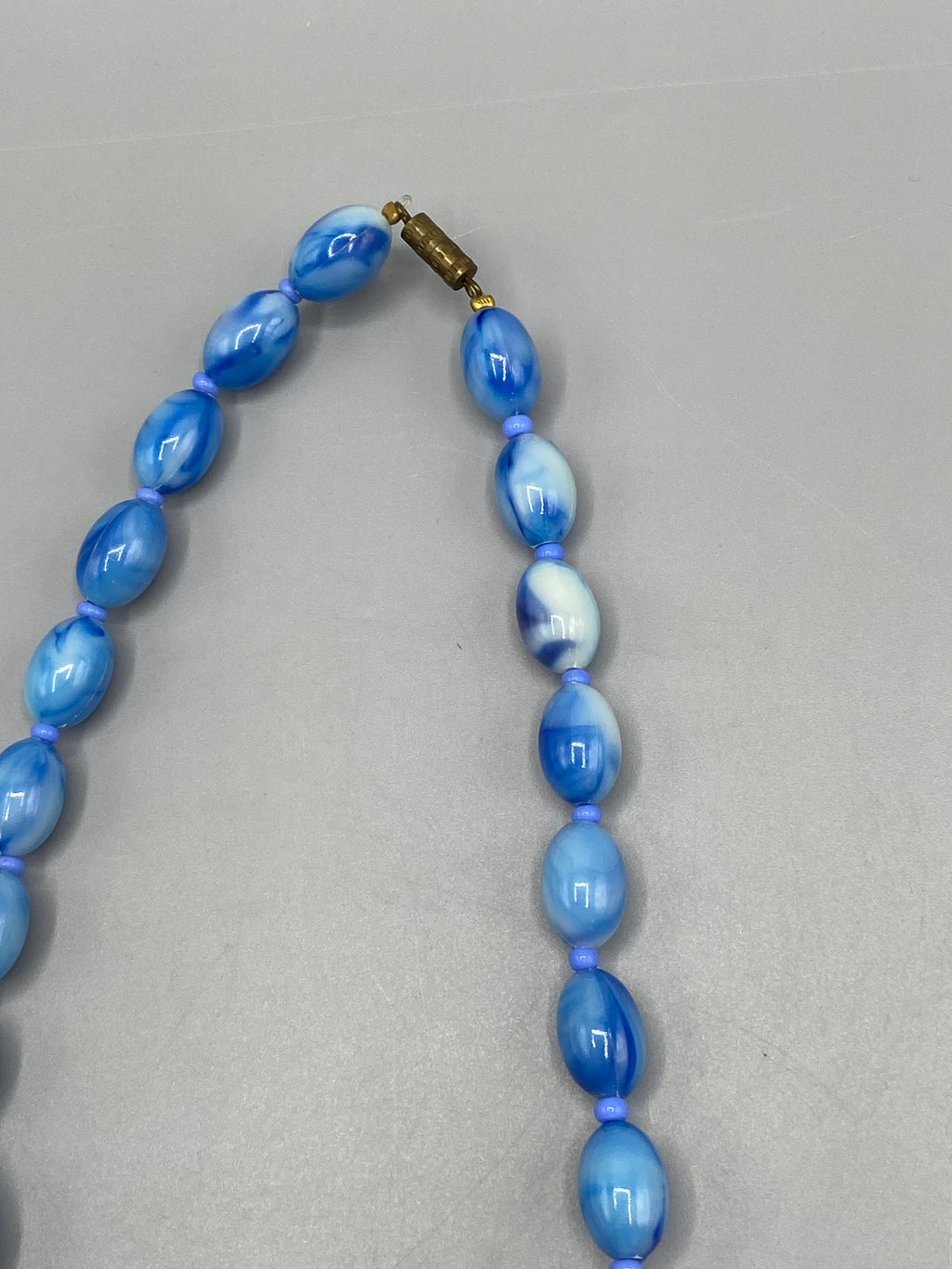 Sautoir vintage perles marbrées bleues – détail fermoir cylindrique doré