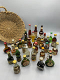 32 mignonnettes anciennes de spiritueux – Vue d'ensemble étalées, cognacs et armagnacs au premier plan