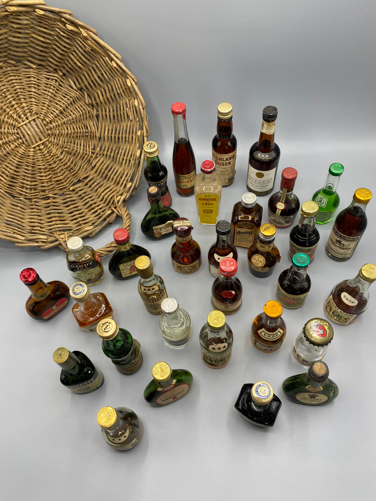 32 mignonnettes anciennes de spiritueux – Vue d'ensemble, Marie Brizard Blackberry et Armagnac Haut-Baron visibles