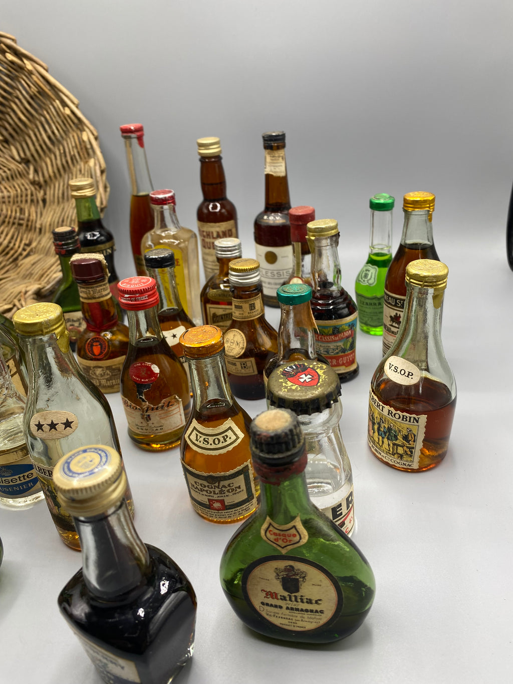 32 mignonnettes anciennes de spiritueux – Vue du panier rempli de dessus, Noisette Brandy et Crema Cacao Mollfulleda visibles