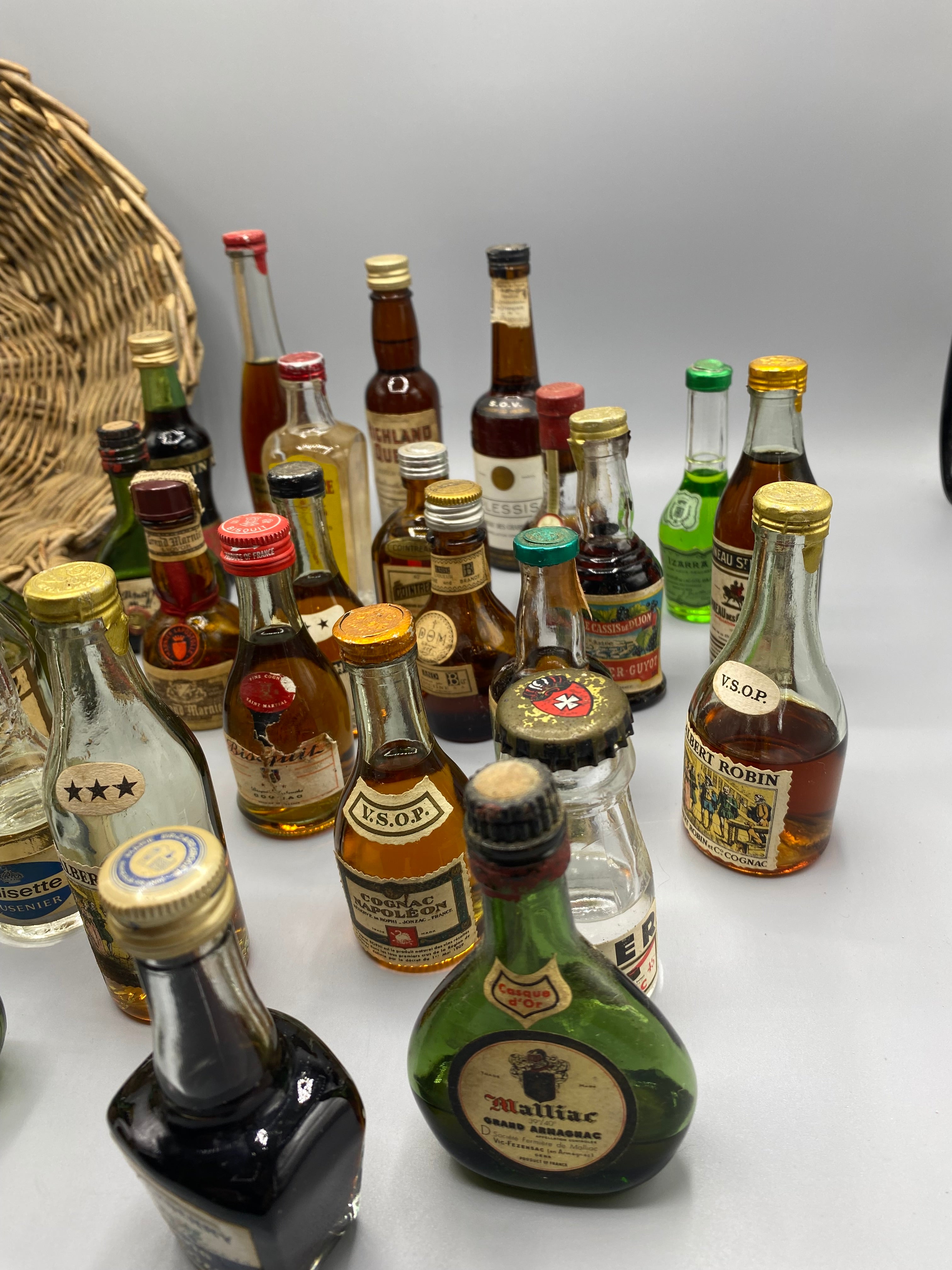 32 mignonnettes anciennes de spiritueux – Vue du panier rempli de dessus, Noisette Brandy et Crema Cacao Mollfulleda visibles