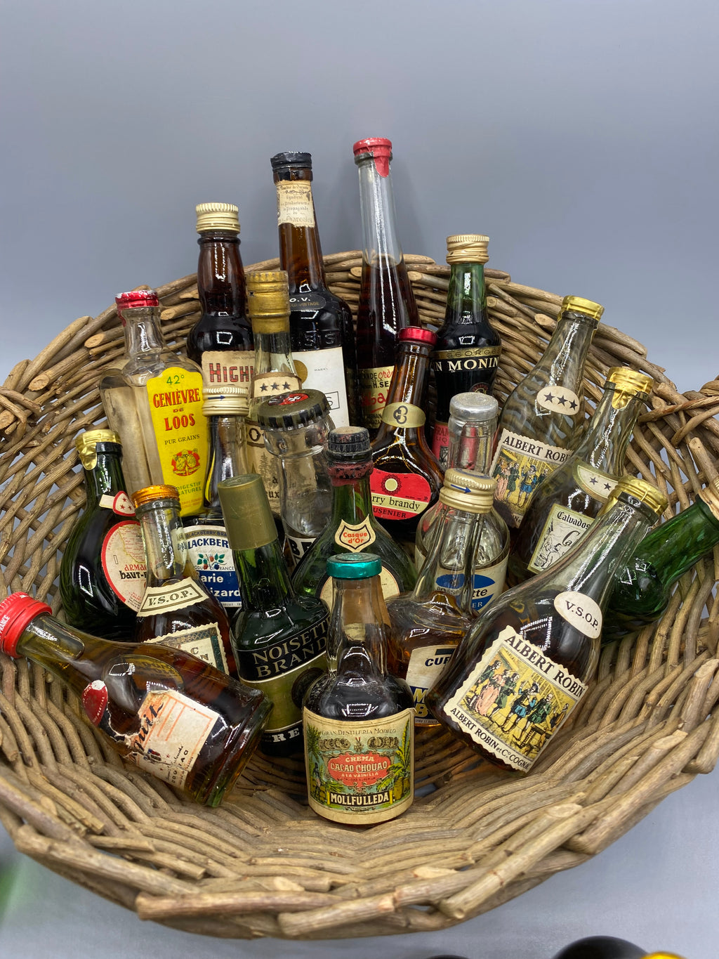 32 mignonnettes anciennes de spiritueux – Vue trois quarts panier plein, Grand Marnier et Pineau St-Martin visibles