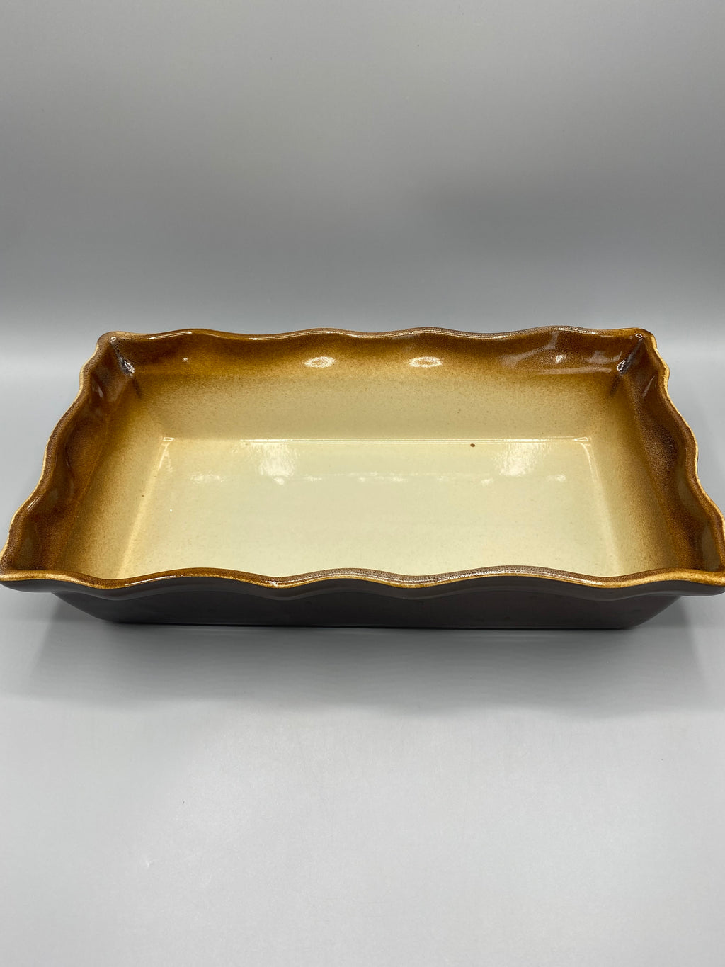 Grand plat à four céramique brun miel et crème – Vue trois quarts, bord festonné et émail caramel doré
