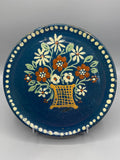 Grand plat mural céramique – vue de face, panier fleuri fond bleu profond