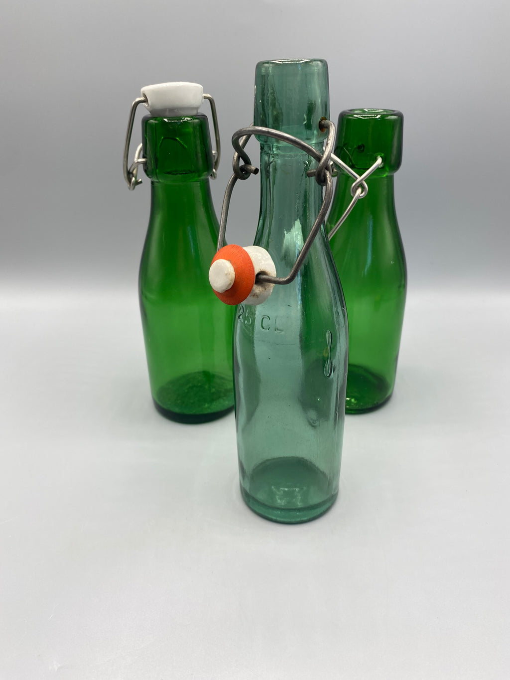 Lot de trois bouteilles anciennes en verre vert et bleu-vert à bouchon mécanique