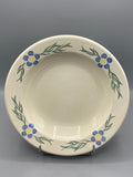Plat creux ancien en faïence ivoire à décor de fleurs bleues, vue générale