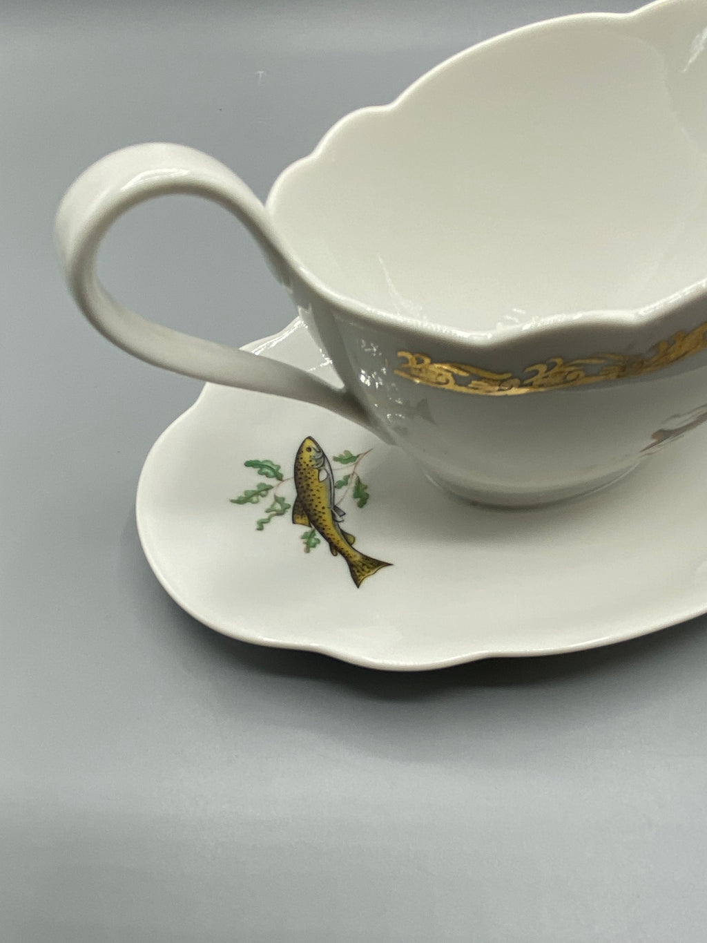 Saucière en porcelaine L’Hirondelle à décor de poissons et frise dorée