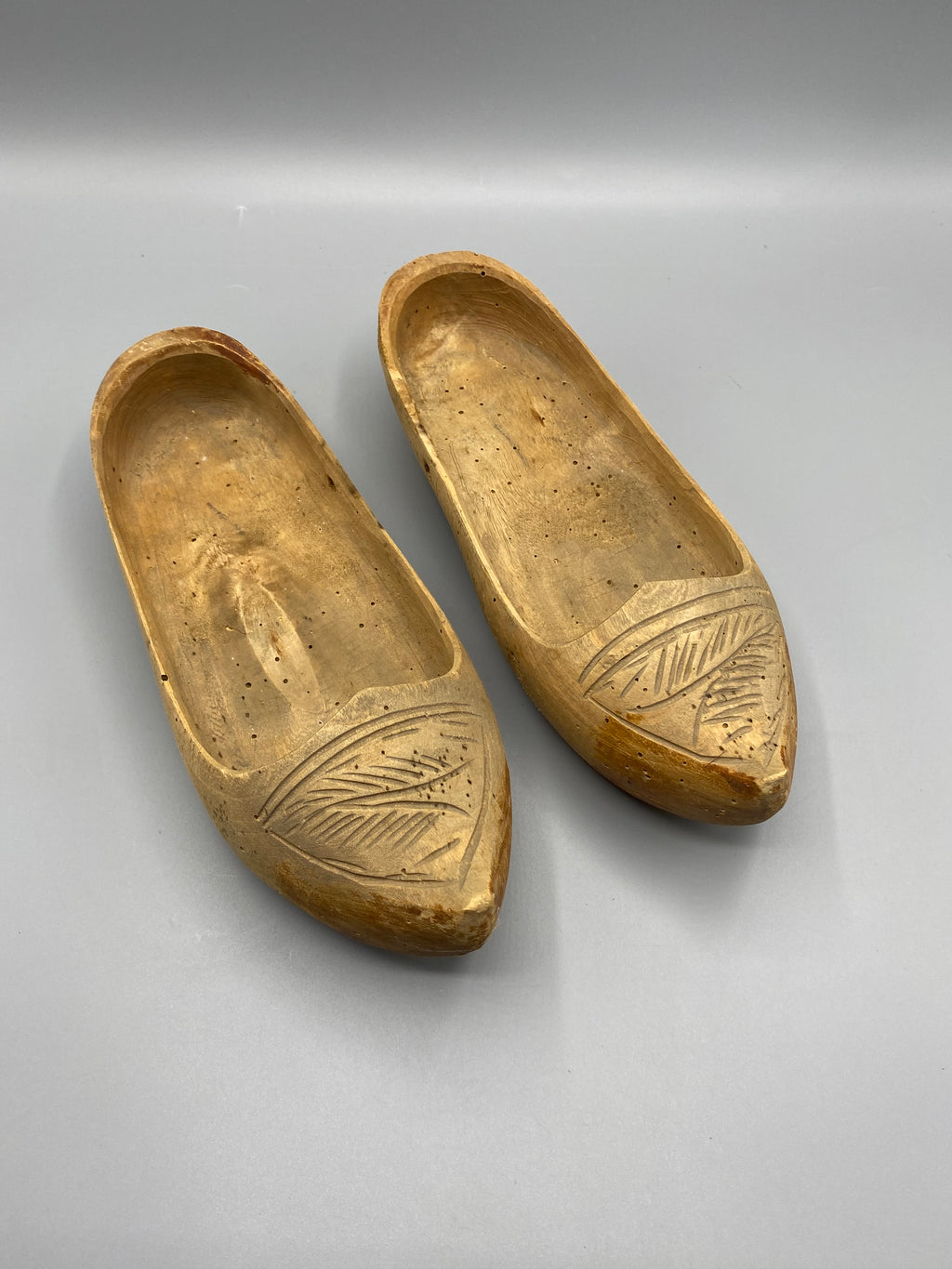 Paire de sabots anciens en bois sculpté à décor de feuilles