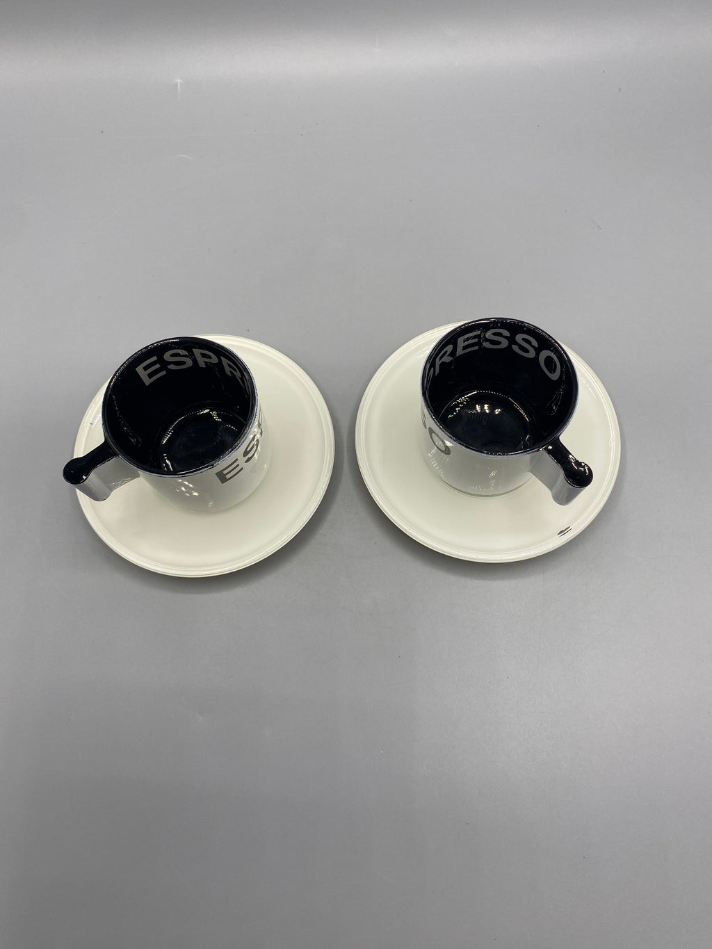 Dessous des deux tasses à espresso et de leurs soucoupes