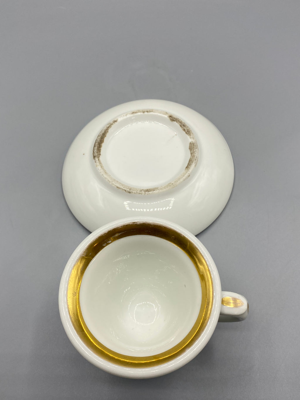 Tasse et sous-tasse en porcelaine blanche ornées de larges filets dorés
