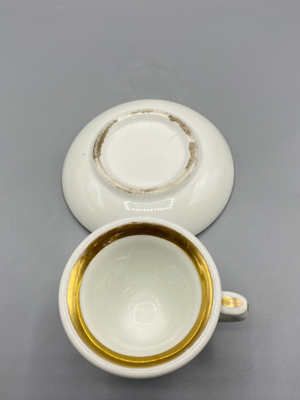 Tasse et sous-tasse en porcelaine blanche ornées de larges filets dorés