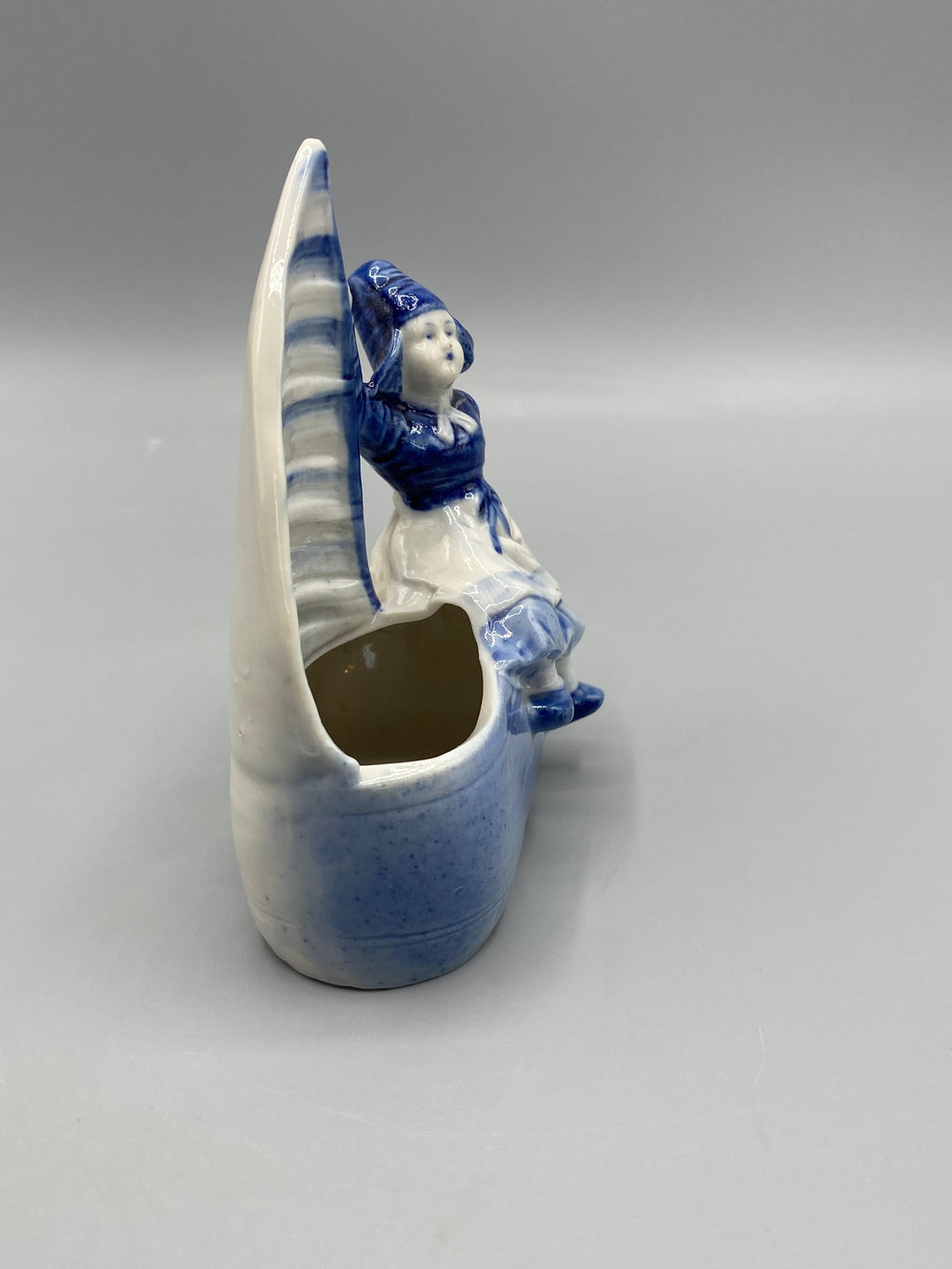 Profil de la figurine en costume hollandais devant une grande voile