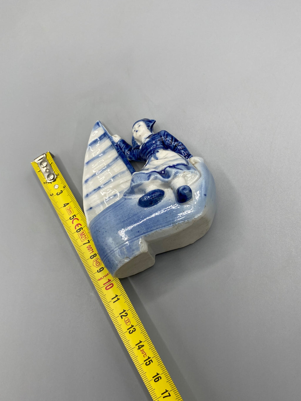 Bibelot ancien représentant une jeune Hollandaise et un voilier bleu et blanc