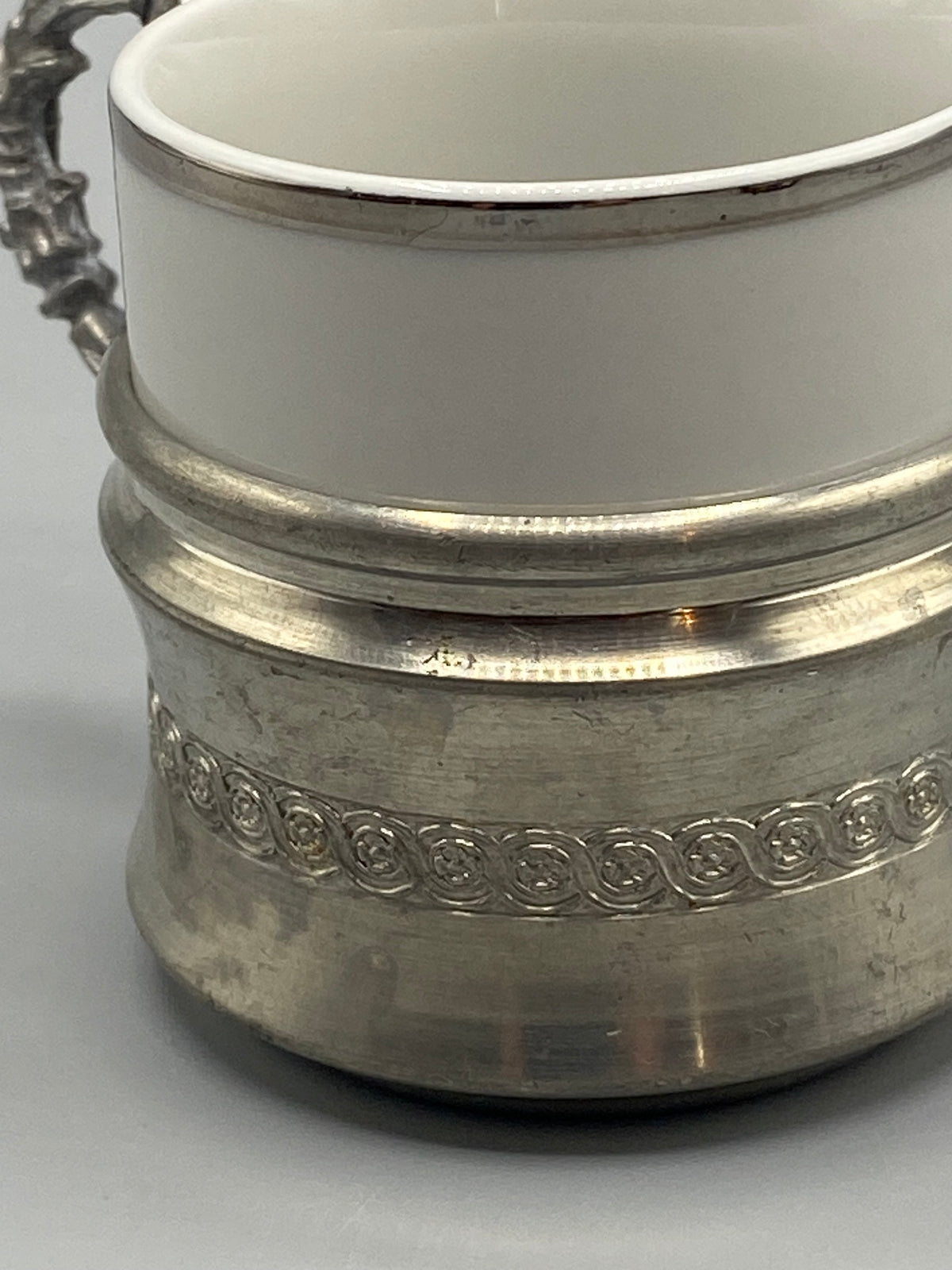 Tasse vintage en porcelaine blanche dans sa monture en étain