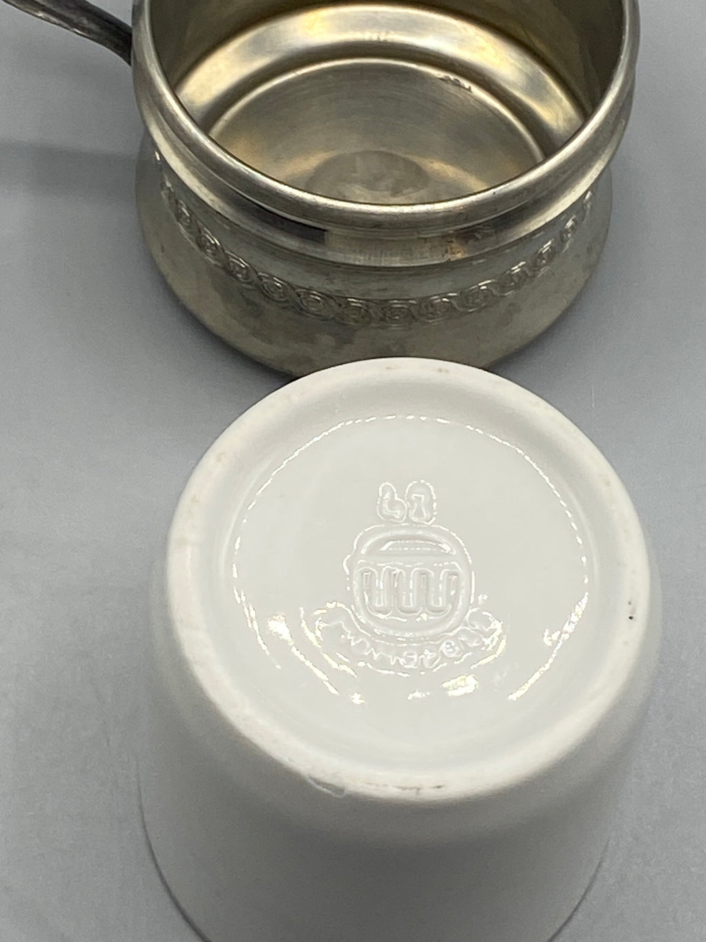 Marque en relief évoquant Moustiers sous la tasse en porcelaine