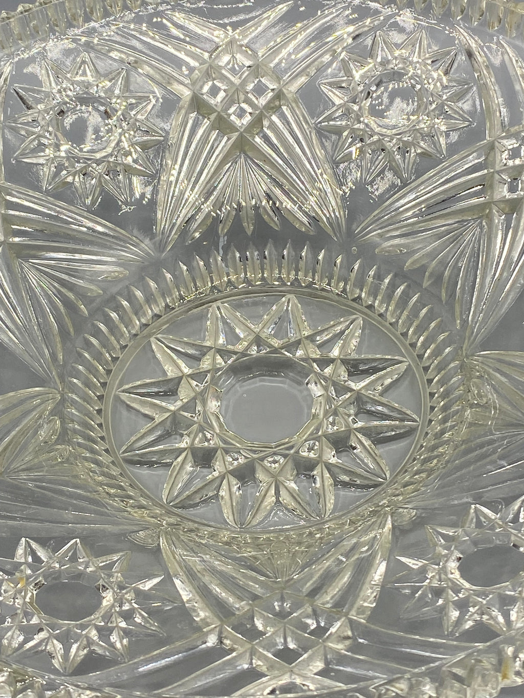 Détail du décor central étoilé de la coupe en verre pressé