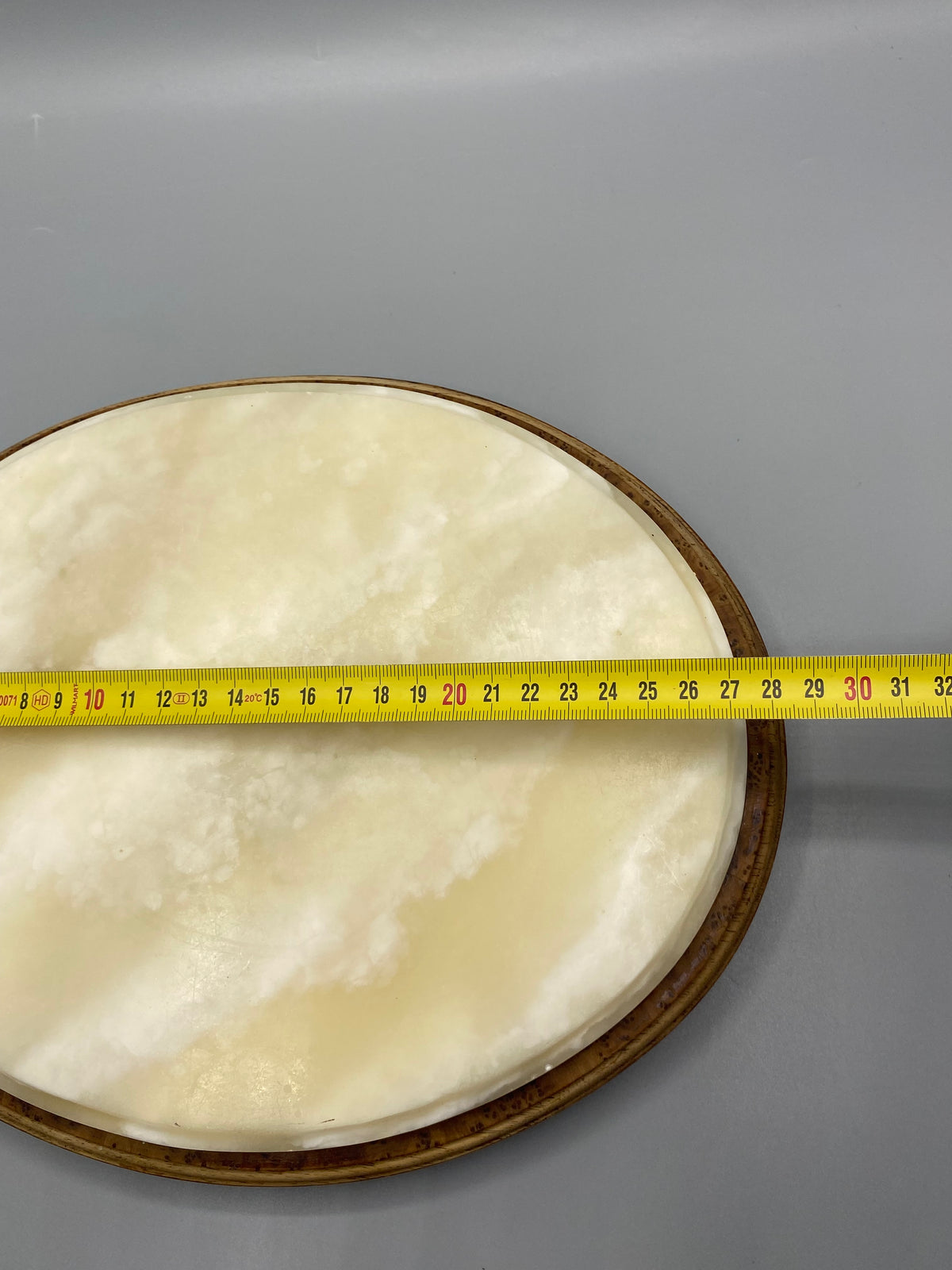 Largeur du dessous de plat en albâtre mesurée au mètre ruban