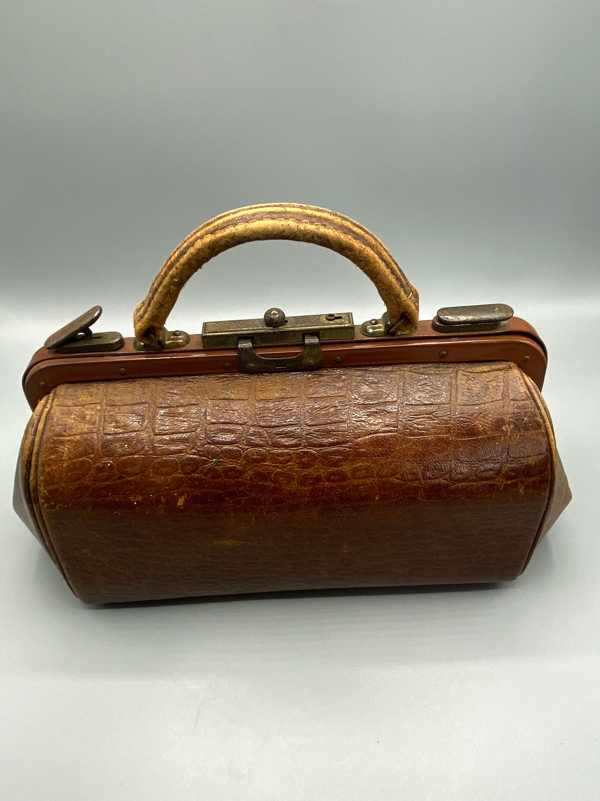 Petit sac Gladstone ancien en cuir brun vu de face, armature et poignée