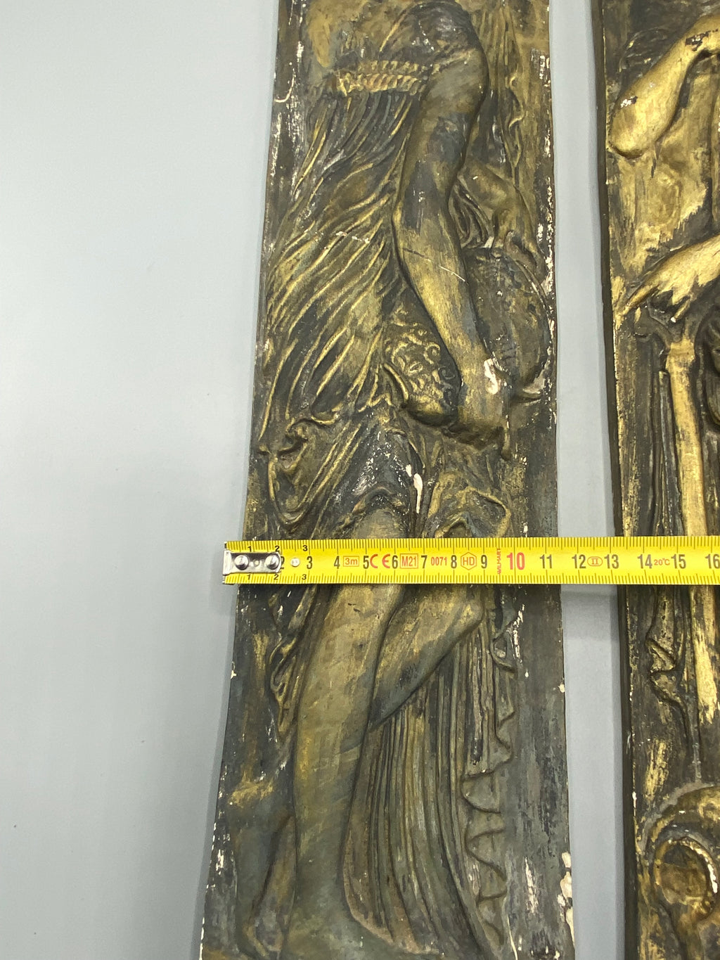 Détail de la patine brune et dorée au pied du bas-relief