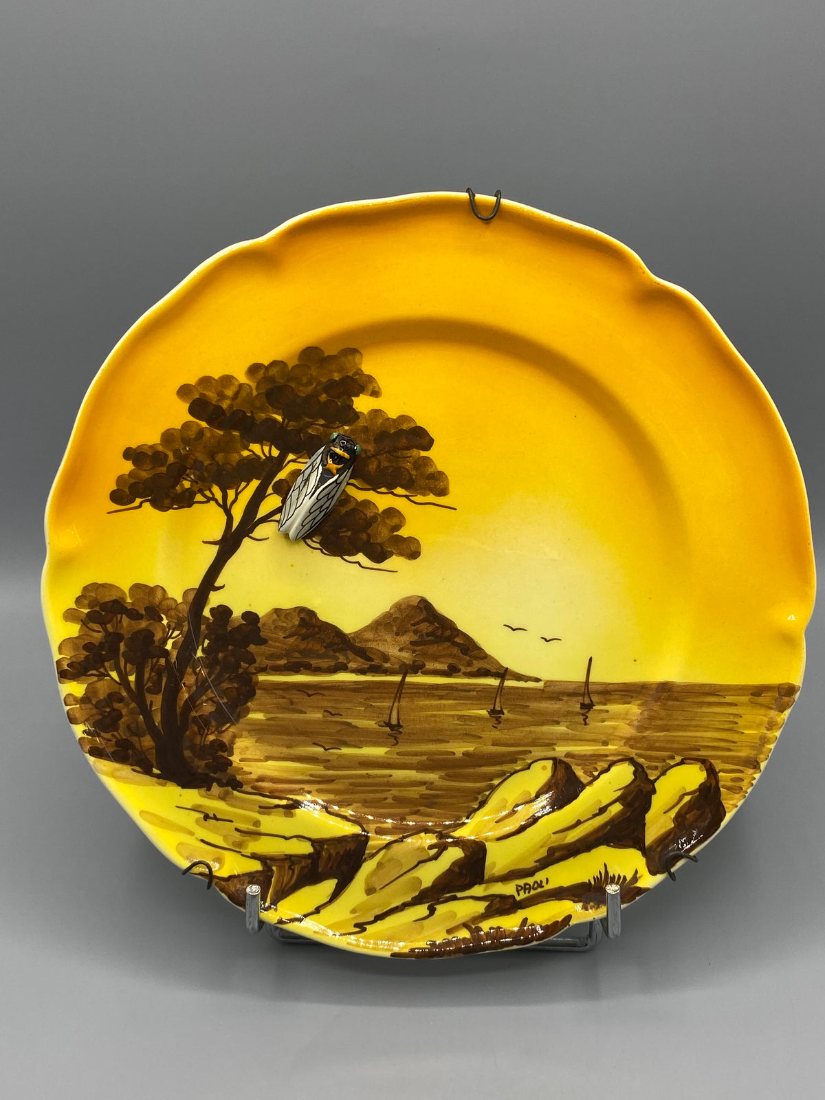 Détail de la cigale en relief sur le décor de pin de l’assiette Paoli