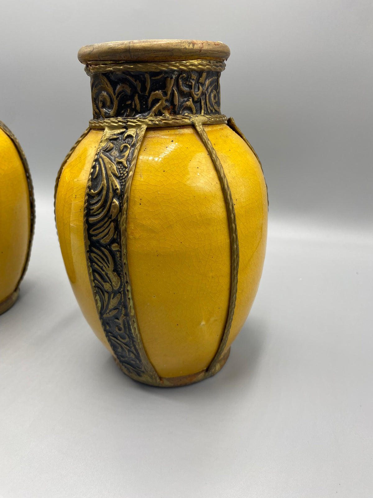 Détail du vase jaune et de ses bandes métalliques