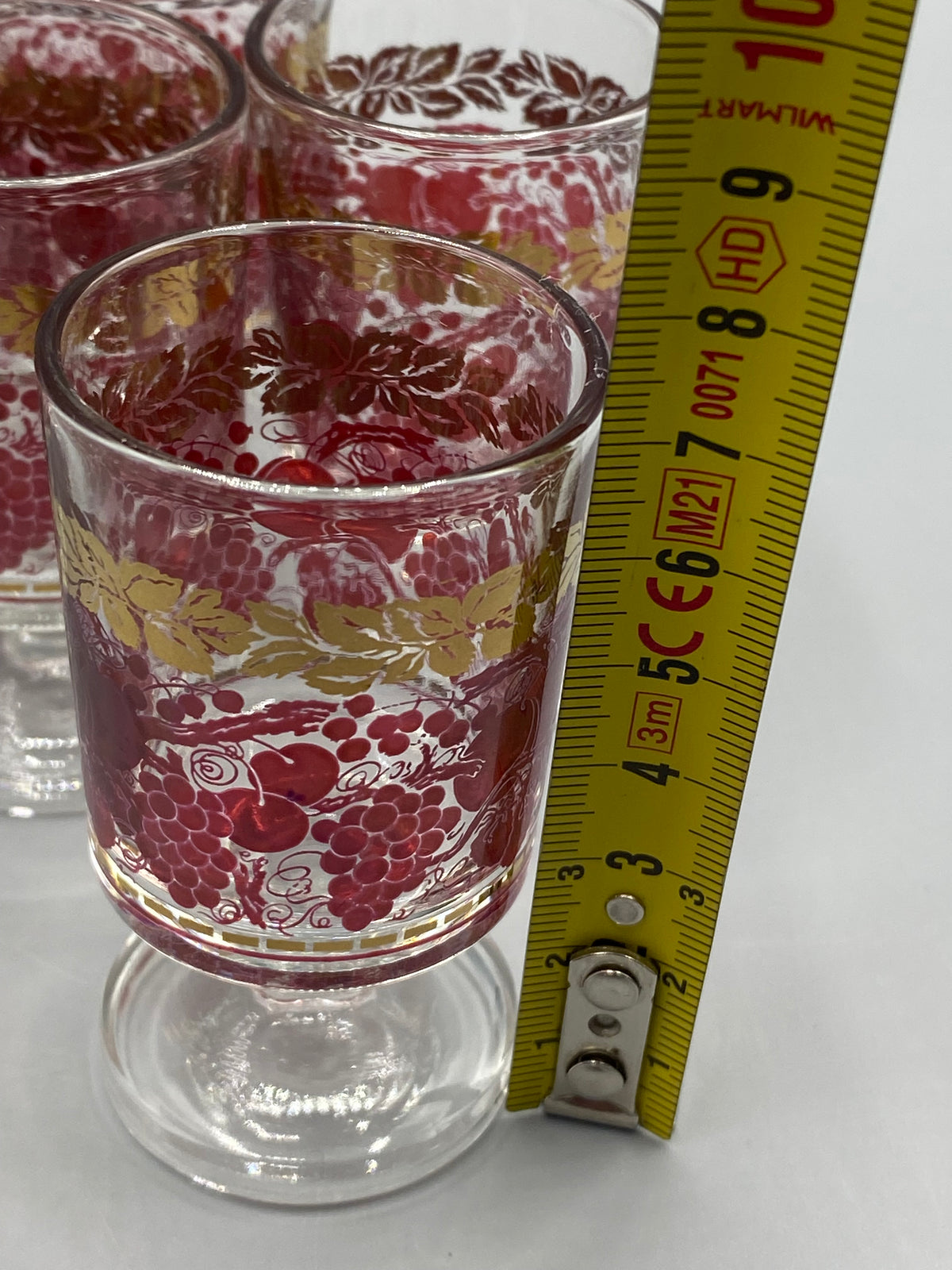Verre à liqueur à pied court photographié avec un mètre pour montrer sa hauteur