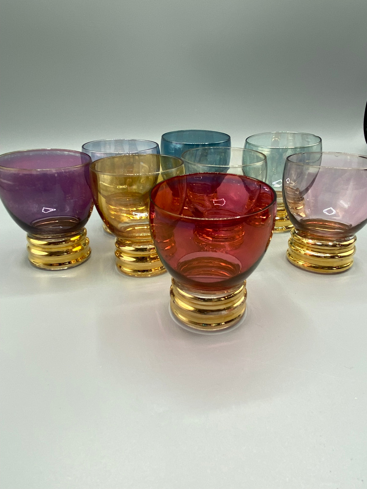 Ensemble de sept verres à liqueur multicolores à pieds dorés des années 1950